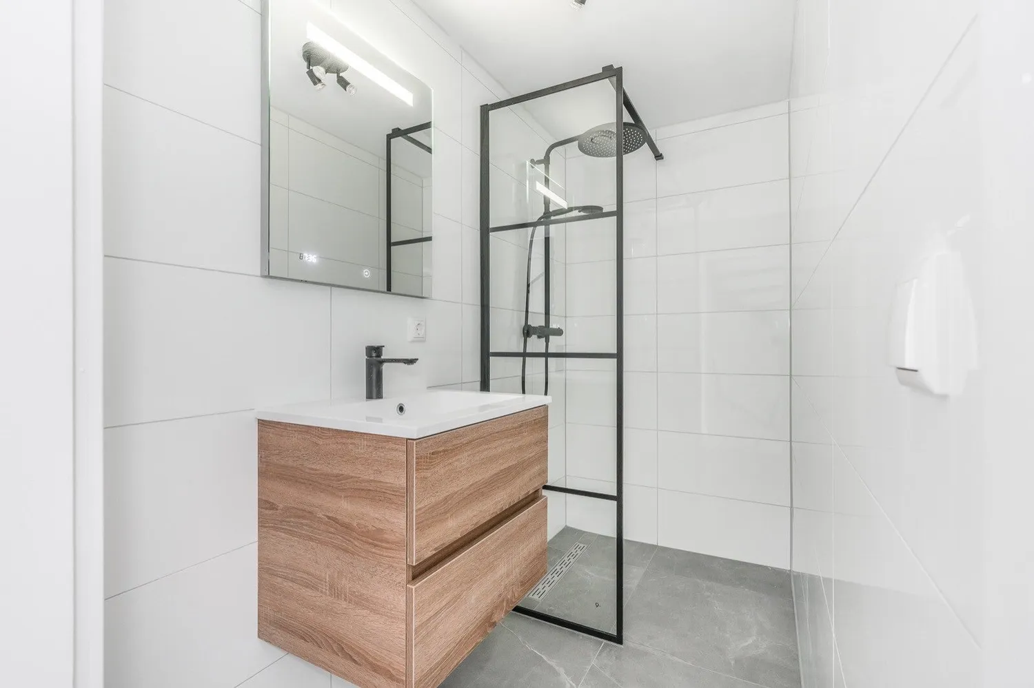 Badkamer na de renovatie: inloopdouche met stalen wand en houten badmeubel