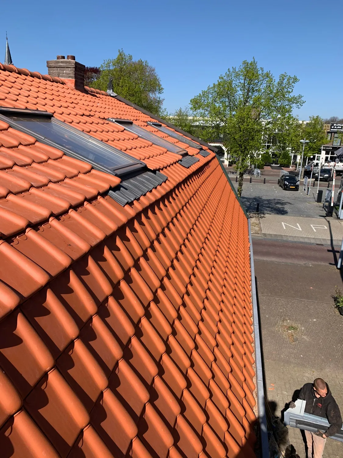 Schoorsteen op de nok van een oranje pannendak