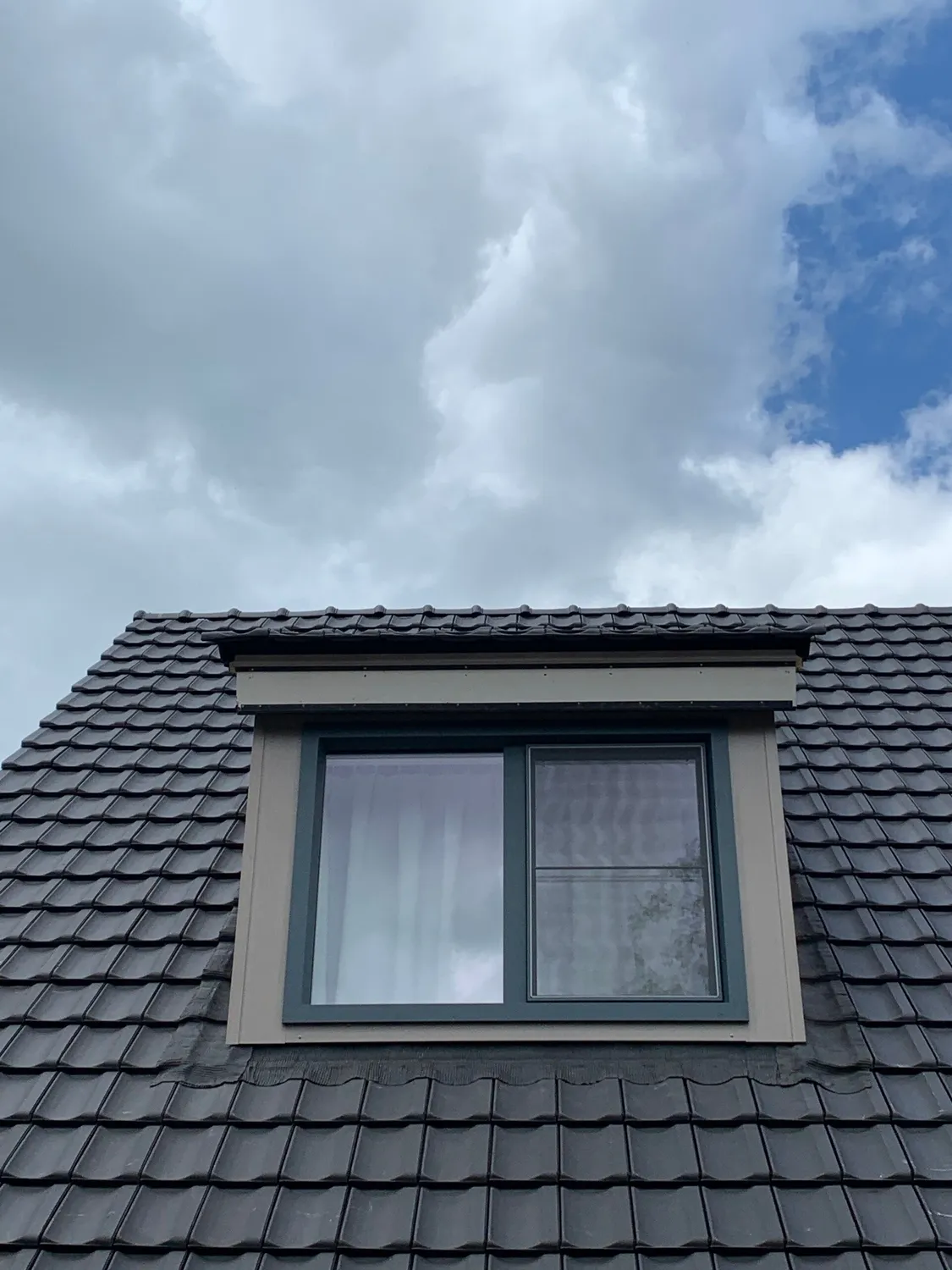 Geplaatste dakkapel met antraciet dakpannen en afgewerkte boeiboord