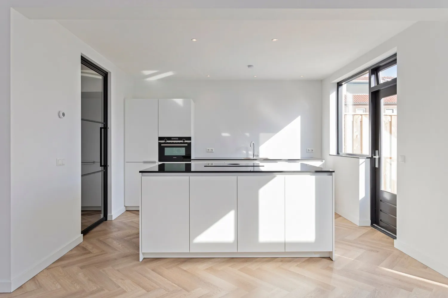 Keuken na de renovatie: kookeiland en visgraatvloer